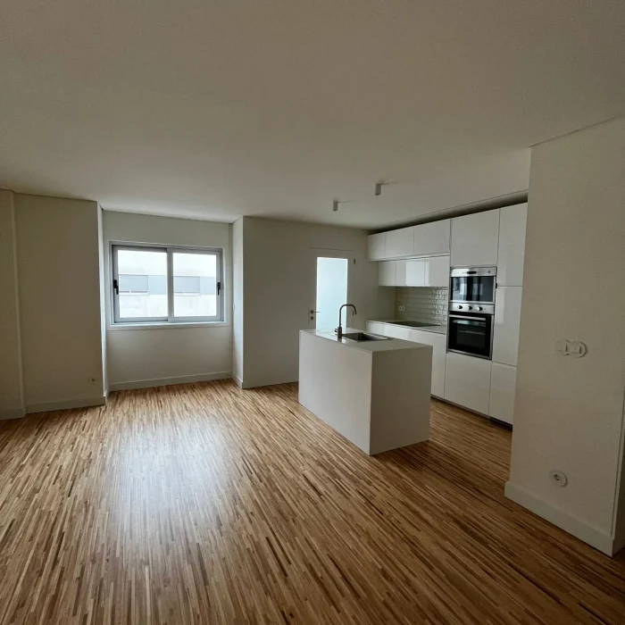 Imagem de uma cozinha completamente remodelada, com design moderno e funcional. A cozinha apresenta armários de linhas clean, bancadas de acabamento elegante, e electrodomésticos de última geração. O espaço é amplo e bem iluminado, com detalhes que valorizam a estética e a praticidade do ambiente.